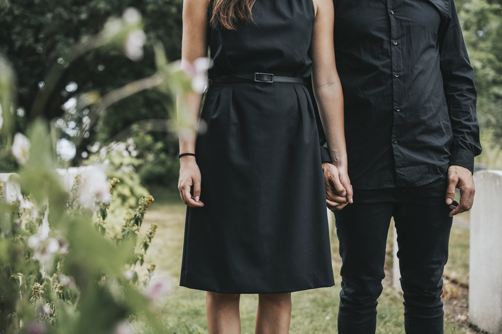 Couple holding hands at a graveyard